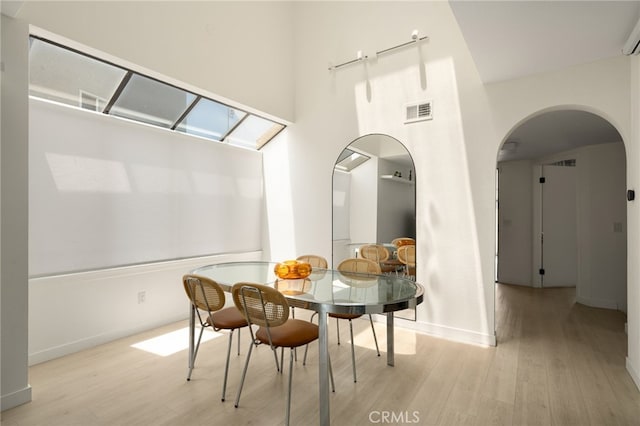 680 E Workman St, Covina, CA 91723 - dining space featuring light wood-style flooring, arched walkways, a towering ceiling, and a skylight