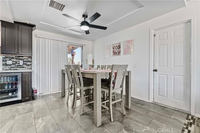 18396 Live Oak St, Hesperia, CA 92345 - dining space with wine cooler, a ceiling fan, and a tray ceiling