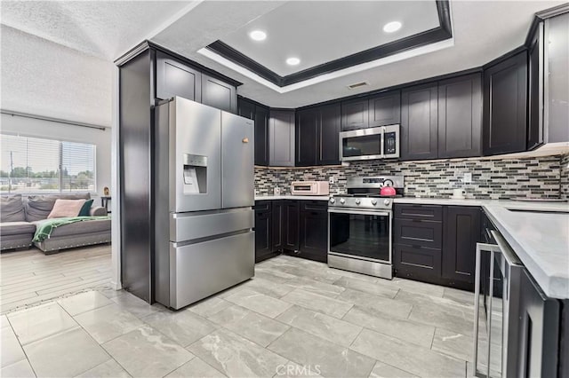 18396 Live Oak St, Hesperia, CA 92345 - kitchen with stainless steel appliances, light countertops, tasteful backsplash, a tray ceiling, and recessed lighting