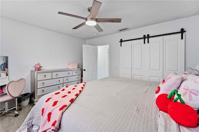 18396 Live Oak St, Hesperia, CA 92345 - bedroom featuring a textured ceiling, a barn door, a closet, and a ceiling fan