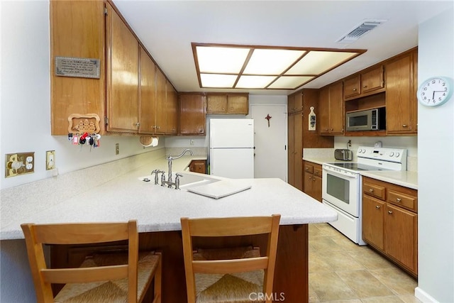 511 W Puente St Unit 4, Covina, CA 91722 - kitchen featuring white appliances, a peninsula, and brown cabinets