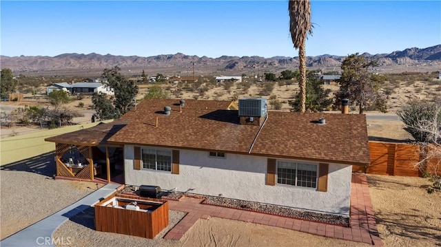 63608 Jadeite St, Joshua Tree, CA 92252 - back of house with stucco siding, a mountain view, and a shingled roof