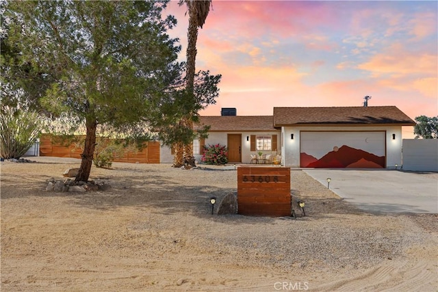 63608 Jadeite St, Joshua Tree, CA 92252 - ranch-style home with concrete driveway, an attached garage, and stucco siding