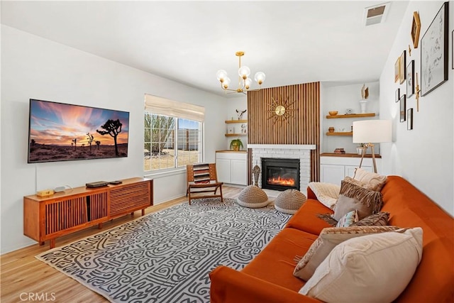 63608 Jadeite St, Joshua Tree, CA 92252 - living room featuring wood finished floors, a chandelier, and a fireplace