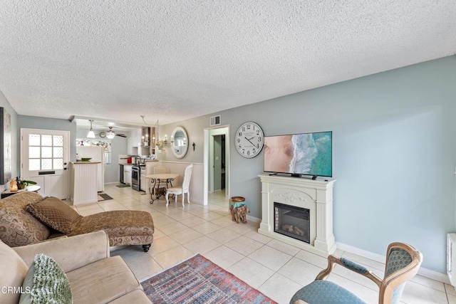 130 E Bay Blvd, Port Hueneme, CA 93041 - living area with a chandelier, light tile patterned floors, a textured ceiling, and a glass covered fireplace