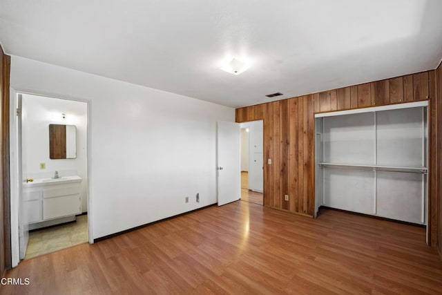 1921 Lincoln Ct, Oxnard, CA 93033 - unfurnished bedroom with light wood-style flooring, a closet, wooden walls, and ensuite bath