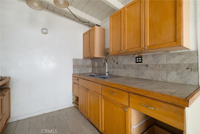 609 S Lassen St, Willows, CA 95988 - kitchen featuring tile countertops, backsplash, brown cabinets, and a wood ceiling with exposed beams
