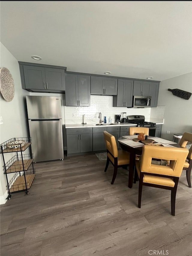1303 W 109th Pl, Los Angeles, CA 90044 - kitchen with stainless steel appliances, dark wood finished floors, light countertops, tasteful backsplash, and recessed lighting