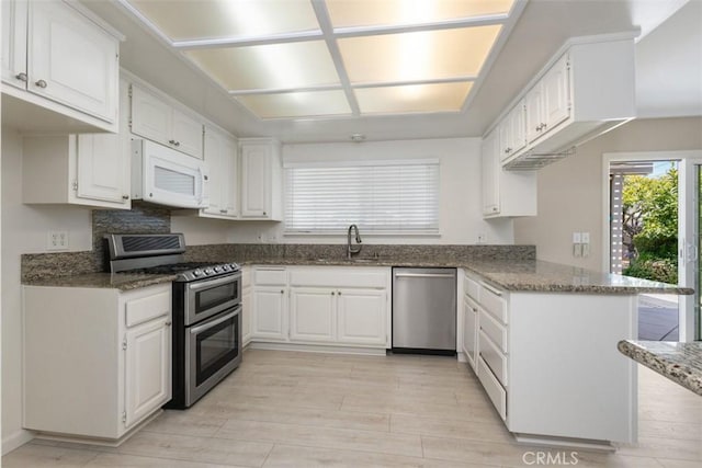 2692 N Fernside St, Orange, CA 92865 - kitchen with appliances with stainless steel finishes, dark stone countertops, white cabinets, and light wood-type flooring