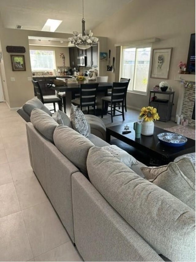 33878 Drifting Sands Cir, Thousand Palms, CA 92276 - living room with a chandelier, light tile patterned floors, and vaulted ceiling
