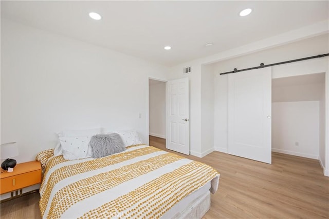 239 N Basilio Ave, San Dimas, CA 91773 - bedroom with a barn door, light wood-type flooring, and recessed lighting