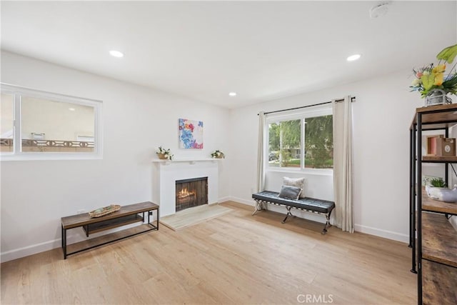 239 N Basilio Ave, San Dimas, CA 91773 - sitting room featuring light wood finished floors, a warm lit fireplace, and recessed lighting