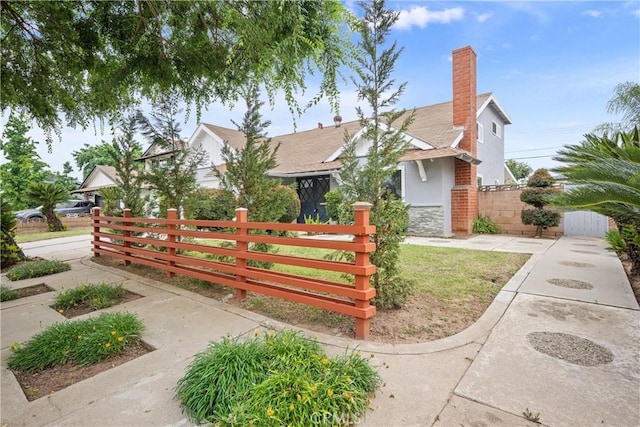 239 N Basilio Ave, San Dimas, CA 91773 - view of front of house featuring a fenced front yard, stone siding, and a chimney