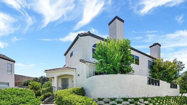 13133 Le Parc Unit 503, Chino Hills, CA 91709 - view of side of home with a chimney, stucco siding, and a tile roof