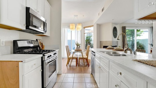 13133 Le Parc Unit 503, Chino Hills, CA 91709 - kitchen featuring appliances with stainless steel finishes, light tile patterned floors, white cabinetry, a chandelier, and light stone countertops