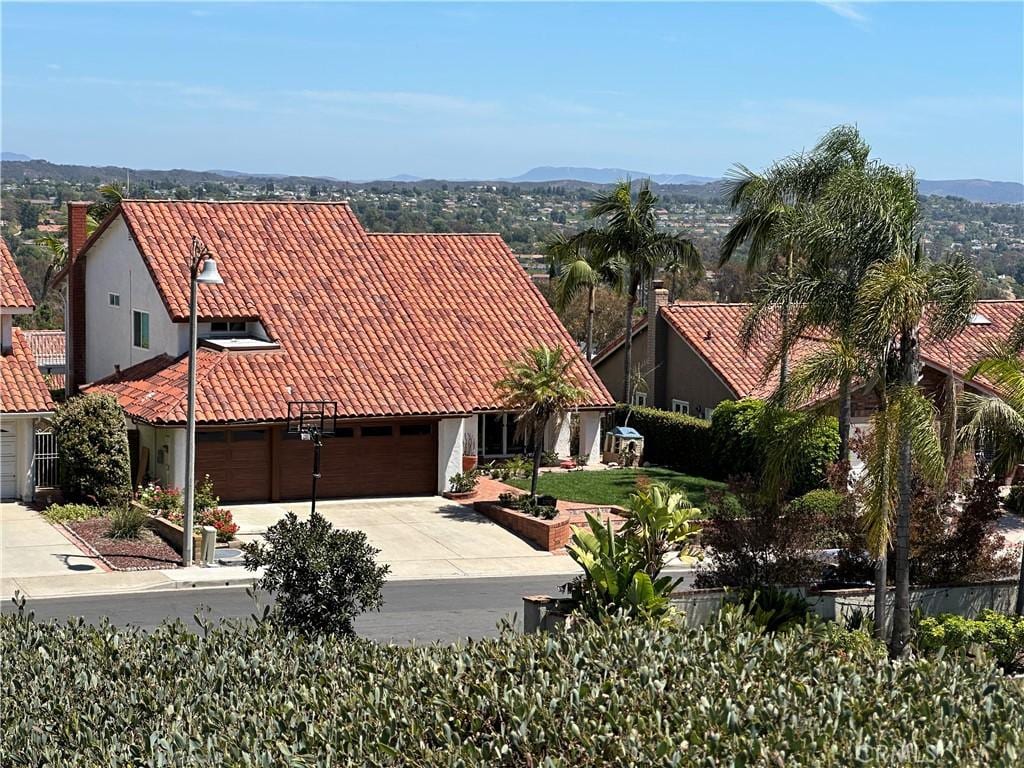 22792 Orellana, Mission Viejo, CA 92691 - view of front of house with a tile roof, concrete driveway, stucco siding, a mountain view, and an attached garage