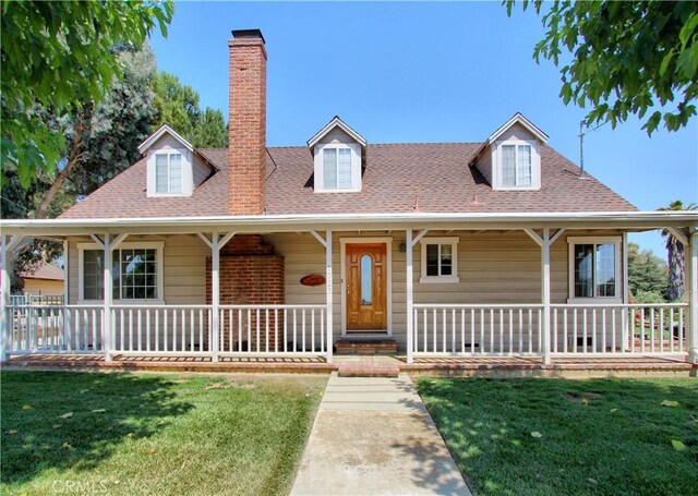 1023 Fremont St, Calimesa, CA 92320 - view of front facade with covered porch, a front yard, a chimney, and a shingled roof
