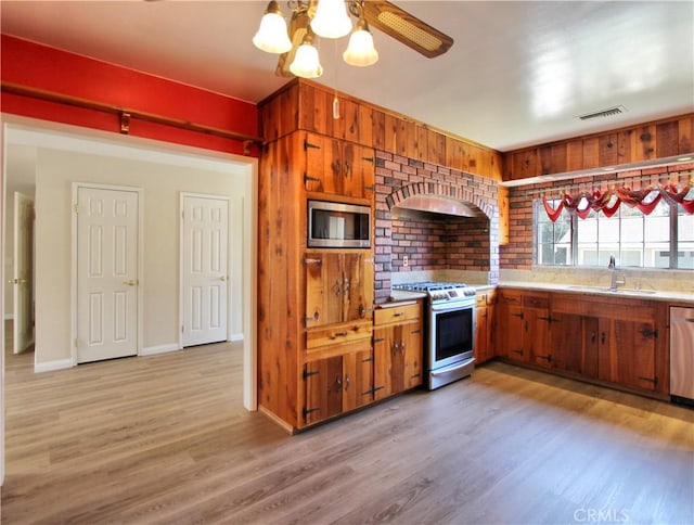 1023 Fremont St, Calimesa, CA 92320 - kitchen featuring stainless steel appliances, light wood-type flooring, brown cabinetry, and light countertops