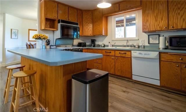 42179 High Point Ct, Ahwahnee, CA 93601 - kitchen featuring white dishwasher, black microwave, wood finished floors, and brown cabinetry