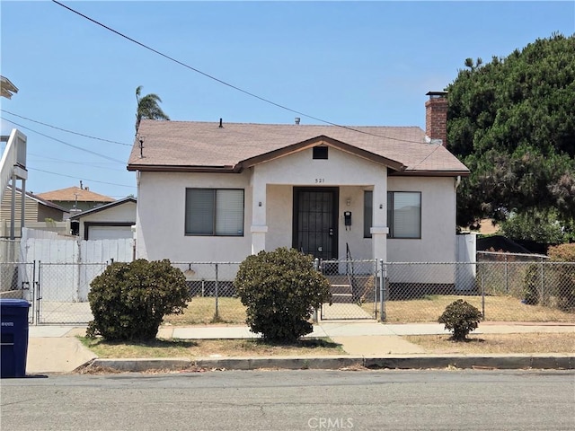 521 E 7th St, National City, CA 91950 - bungalow-style home featuring a gate, stucco siding, a fenced front yard, and roof with shingles