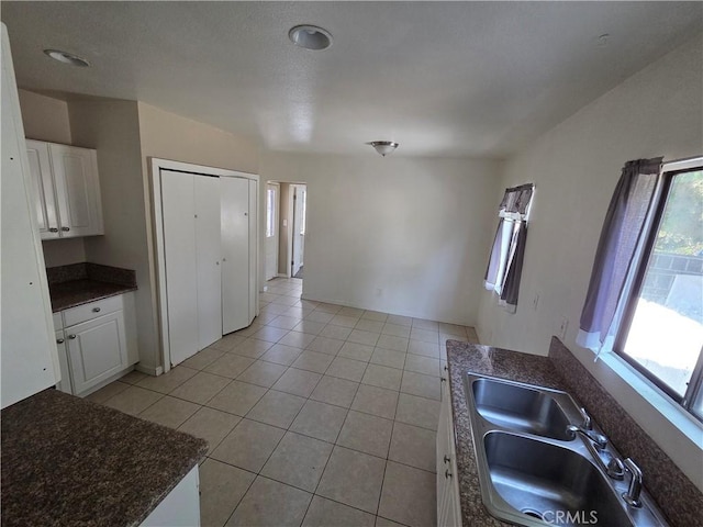 521 E 7th St, National City, CA 91950 - kitchen featuring dark countertops, light tile patterned floors, and white cabinetry