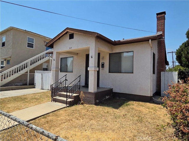 521 E 7th St, National City, CA 91950 - view of front of house featuring a chimney, stucco siding, and stairway