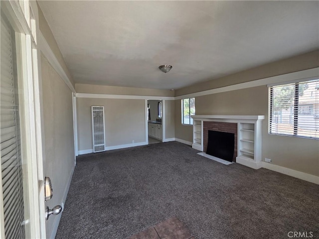 521 E 7th St, National City, CA 91950 - unfurnished living room with dark carpet and a fireplace
