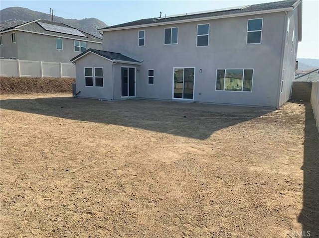 7453 Grazing Ln, Riverside, CA 92507 - back of house with a mountain view, a fenced backyard, and stucco siding