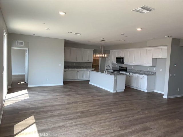 7453 Grazing Ln, Riverside, CA 92507 - kitchen with stainless steel range with electric stovetop, dark wood-type flooring, white cabinetry, a center island with sink, and recessed lighting