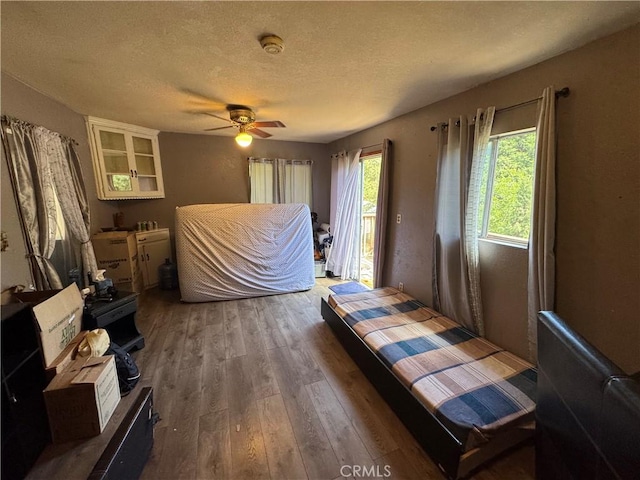 23789 Zuger, Crestline, CA 92325 - bedroom featuring wood finished floors, access to exterior, a textured ceiling, and ceiling fan