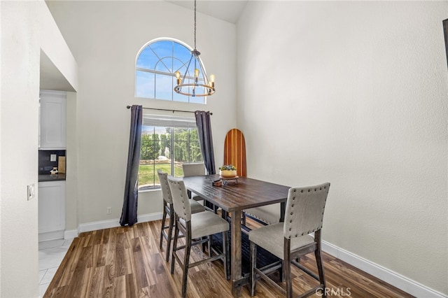 13106 Thicket Pl, Corona, CA 92883 - dining area with wood finished floors, a chandelier, and a high ceiling