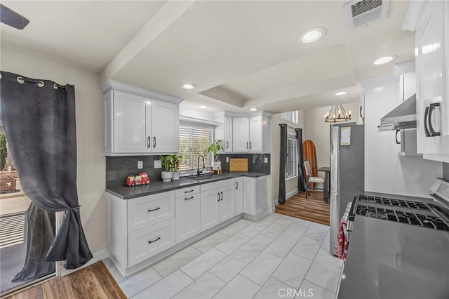 13106 Thicket Pl, Corona, CA 92883 - kitchen featuring ventilation hood, appliances with stainless steel finishes, dark countertops, white cabinets, and recessed lighting