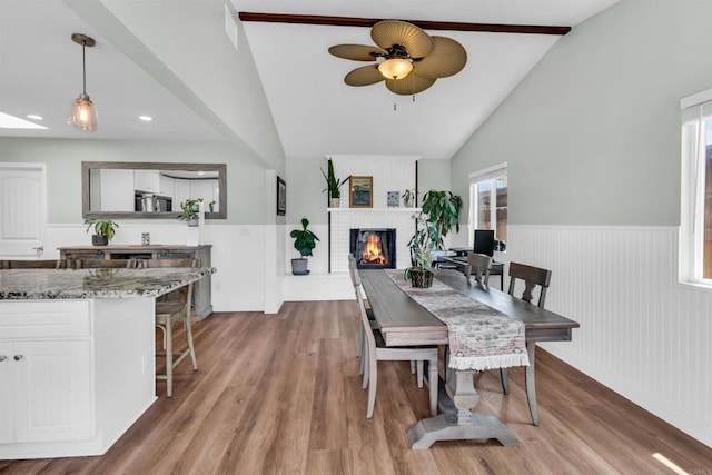 552 Emory St, Imperial Beach, CA 91932 - dining space featuring lofted ceiling, a wainscoted wall, a fireplace, ceiling fan, and wood finished floors