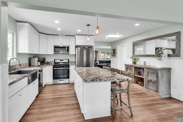 552 Emory St, Imperial Beach, CA 91932 - kitchen featuring appliances with stainless steel finishes, light stone counters, a kitchen island, a breakfast bar area, and recessed lighting