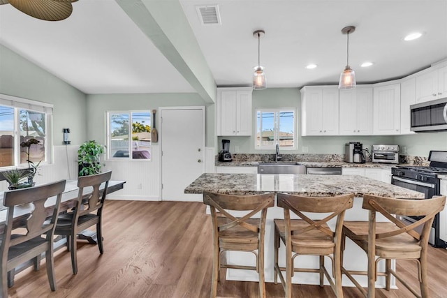 552 Emory St, Imperial Beach, CA 91932 - kitchen with appliances with stainless steel finishes, light wood finished floors, white cabinets, light stone counters, and pendant lighting