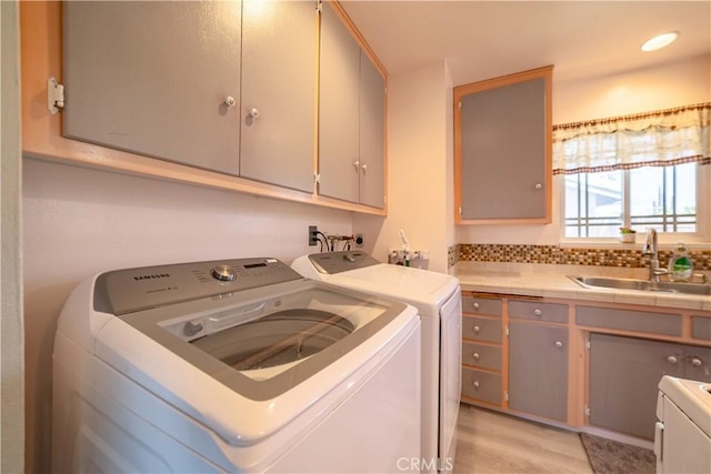 24561 Sinaloa St, Moreno Valley, CA 92557 - laundry area featuring cabinet space, washing machine and clothes dryer, and light wood finished floors