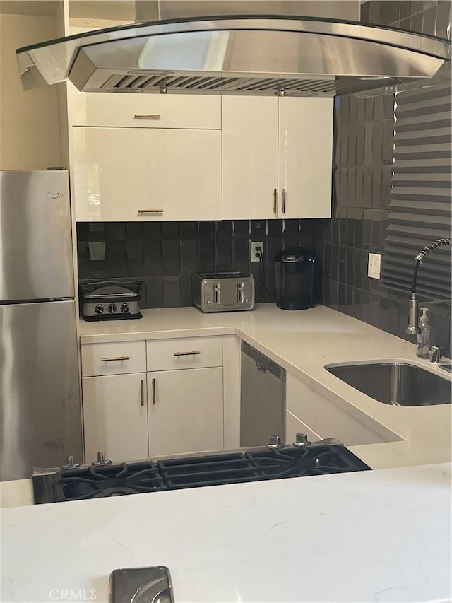 1192 Mitchell Unit 7, Tustin, CA 92780 - kitchen with appliances with stainless steel finishes, decorative backsplash, white cabinetry, and light countertops
