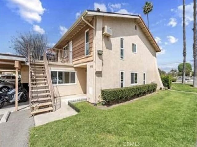 1192 Mitchell Unit 7, Tustin, CA 92780 - back of property with stucco siding, a yard, stairway, and a carport