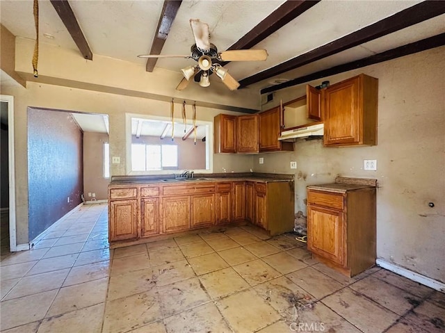 27331 Perkins Rd, Madera, CA 93637 - kitchen with brown cabinetry, beamed ceiling, under cabinet range hood, and a ceiling fan