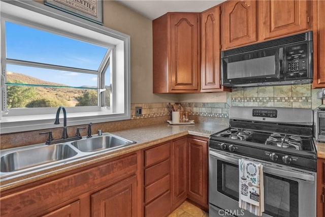 36227 Montezuma Valley Rd, Ranchita, CA 92066 - kitchen featuring gas stove, black microwave, tasteful backsplash, and brown cabinetry