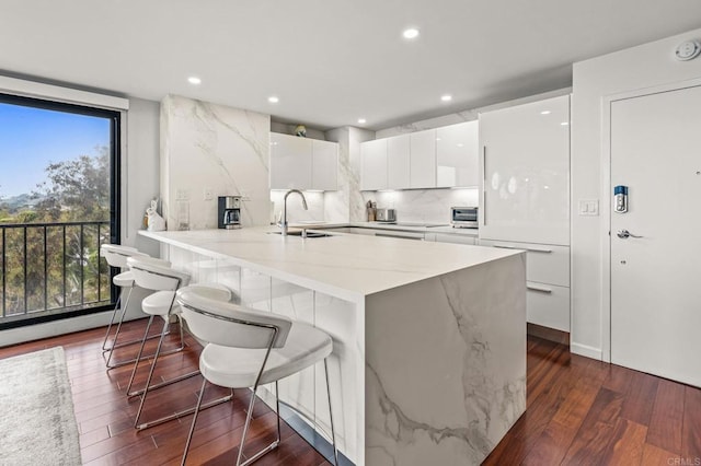 2500 Torrey Pines Rd Unit 805, La Jolla, CA 92037 - kitchen with modern cabinets, white cabinets, dark wood finished floors, recessed lighting, and a breakfast bar