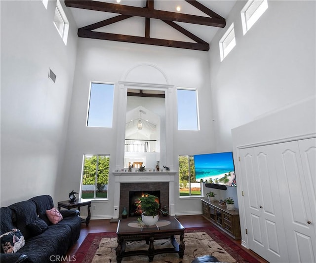 40620 Via Ranchitos, Fallbrook, CA 92028 - living room with high vaulted ceiling, wood finished floors, beam ceiling, a lit fireplace, and healthy amount of natural light