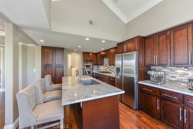38 Toulon, Laguna Niguel, CA 92677 - kitchen with appliances with stainless steel finishes, ornamental molding, dark wood-style floors, light stone counters, and backsplash