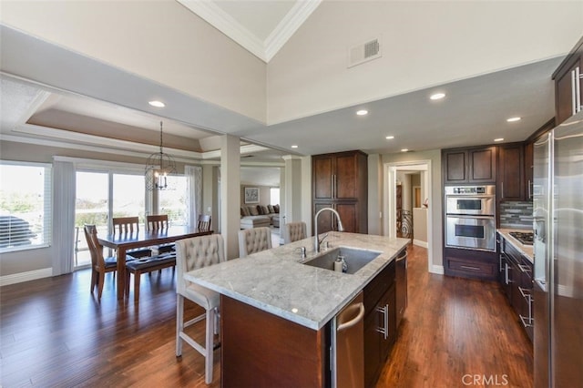 38 Toulon, Laguna Niguel, CA 92677 - kitchen with stainless steel appliances, crown molding, light stone countertops, a center island with sink, and tasteful backsplash