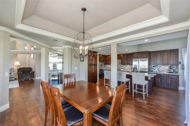 38 Toulon, Laguna Niguel, CA 92677 - dining area featuring a tray ceiling, a chandelier, dark wood-style floors, and ornamental molding