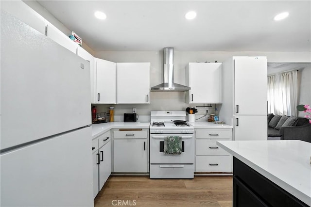 9562 Locust Ave, Fontana, CA 92335 - kitchen with white appliances, wall chimney range hood, light countertops, white cabinets, and light wood-style floors