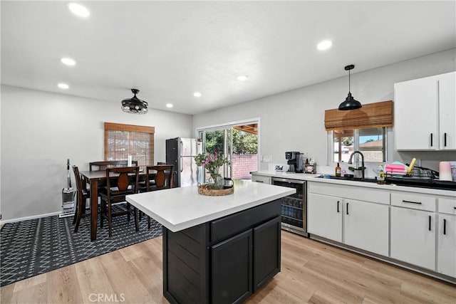 9562 Locust Ave, Fontana, CA 92335 - kitchen featuring wine cooler, white cabinetry, a kitchen island, light countertops, and pendant lighting