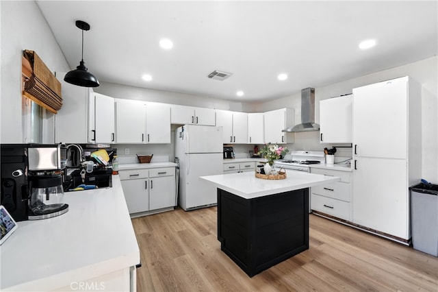 9562 Locust Ave, Fontana, CA 92335 - kitchen with freestanding refrigerator, wall chimney range hood, light countertops, light wood finished floors, and white cabinets