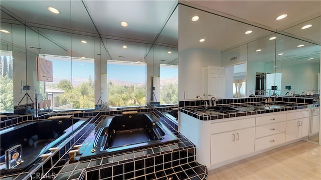22500 N Summit Ridge Cir, Chatsworth, CA 91311 - full bath with double vanity, a tub with jets, healthy amount of natural light, recessed lighting, and wood finished floors