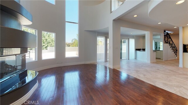 22500 N Summit Ridge Cir, Chatsworth, CA 91311 - unfurnished living room with recessed lighting, stairs, wood finished floors, and a high ceiling